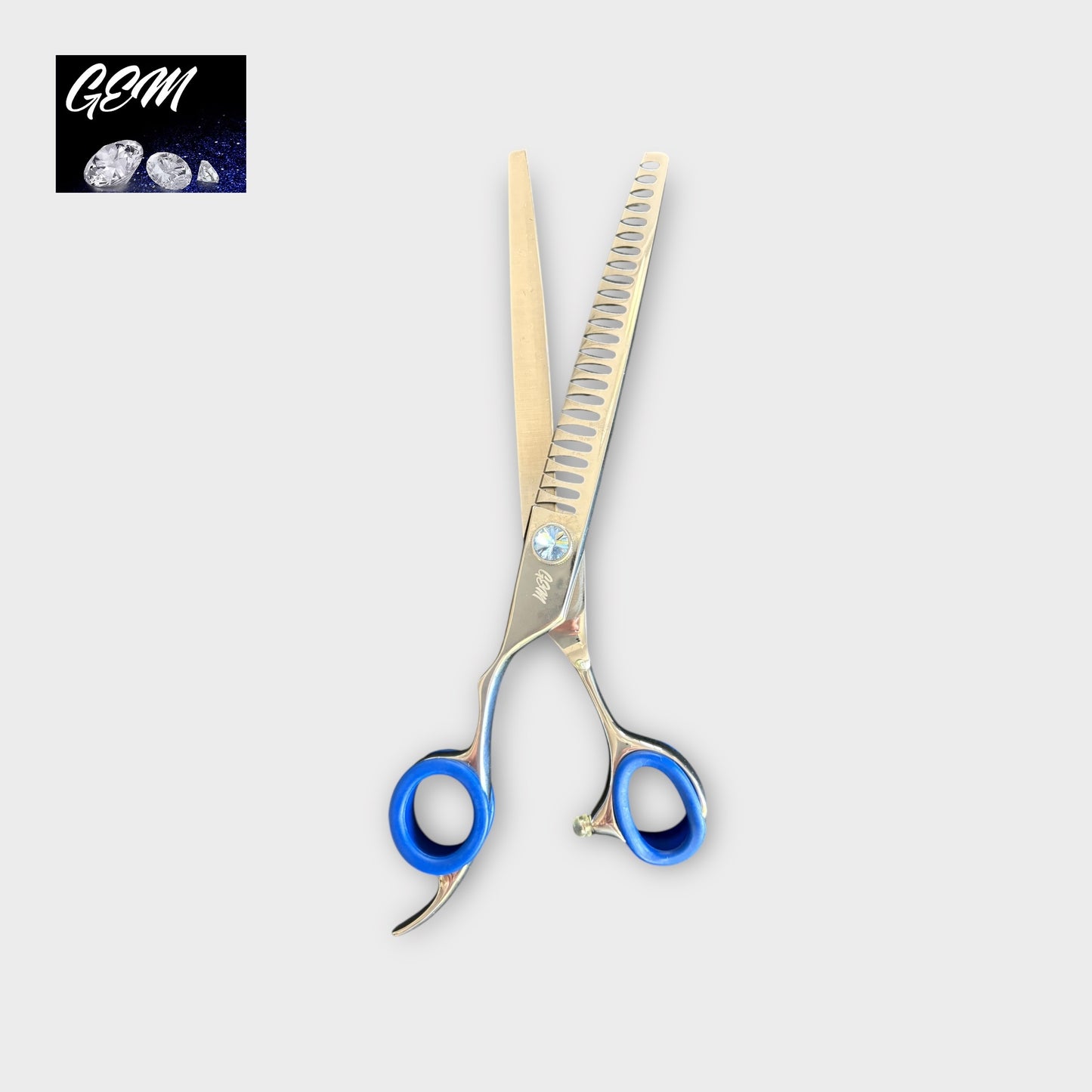The GEM Blue Stone Straight Chunkers 7.5" Lefthanded Scissors feature blue finger grips and a forged design, shown on a light grey background with the GEM logo and gemstone images in the top left corner.