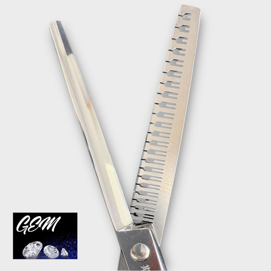 A close-up of GEM Supreme Straight Eraser 7" Scissors, featuring one serrated and one straight blade. The corner displays the GEM logo with three diamonds on a dark blue background, emphasizing professional grooming tools.