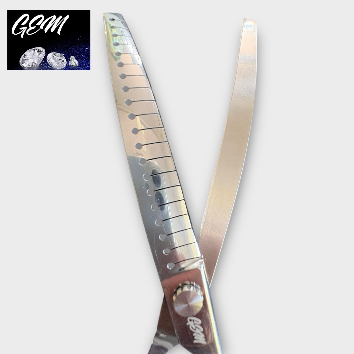 Close-up of GEM Supreme Curved Chunkers 7.5" Scissors made from premium Aichi steel, with one serrated and one smooth blade. The GEM logo with diamond images appears in the top left corner against a dark background.