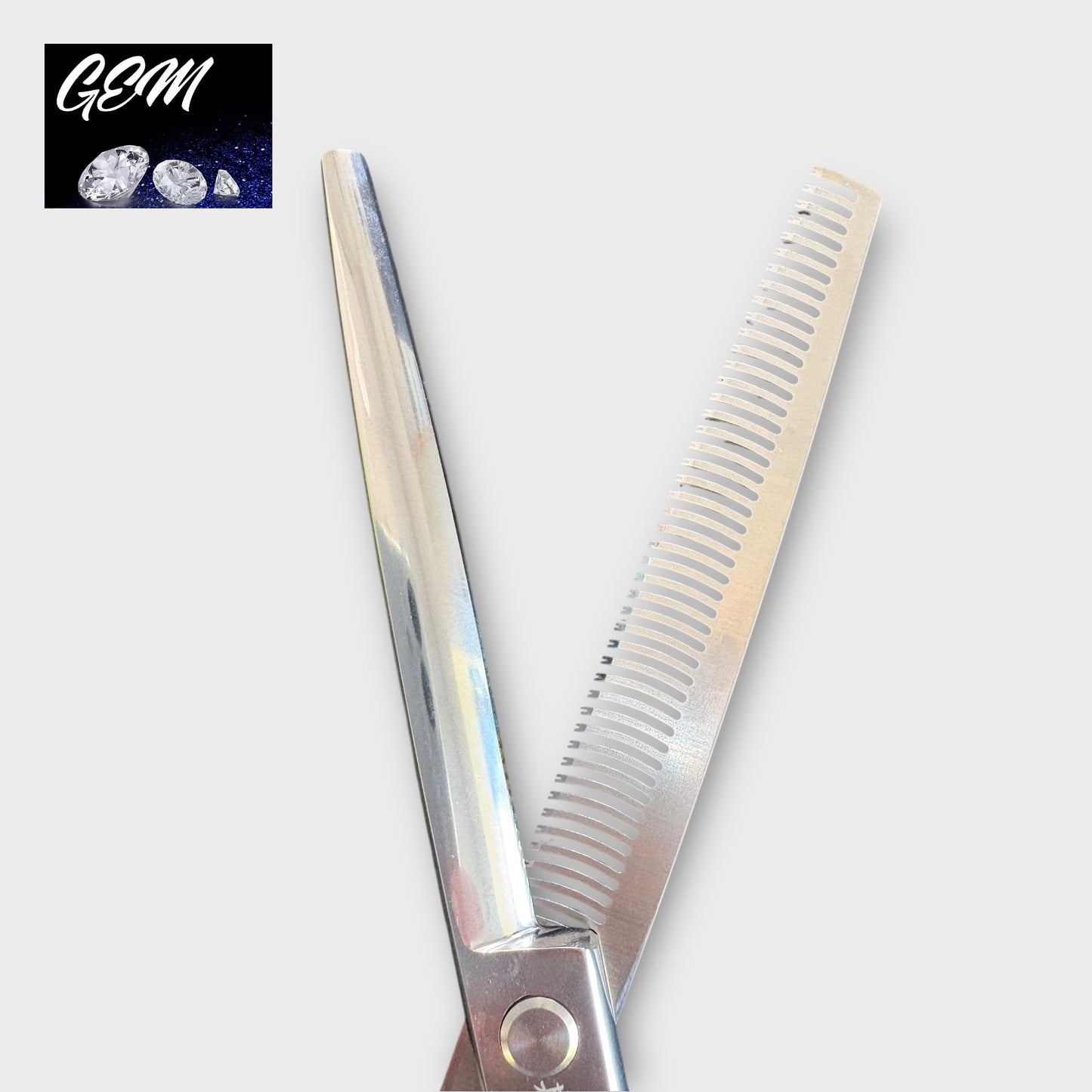 The GEM Supreme Straight Thinners 7" Scissors are open professional thinning shears made from Aichi Steel, with one serrated and one smooth blade. The top left corner features a GEM logo with gemstone images.
