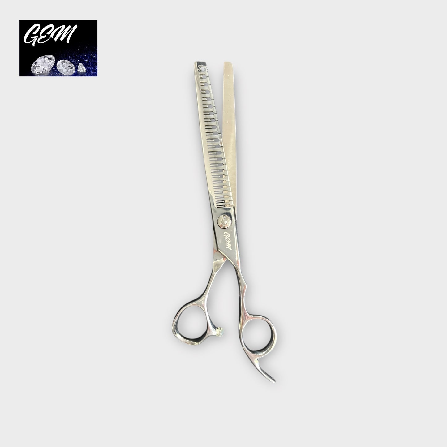 A pair of GEM Supreme Straight Eraser 7" silver thinning scissors with one serrated and one straight blade, shown on a light gray background. The GSM logo with moons is displayed in the top left corner.