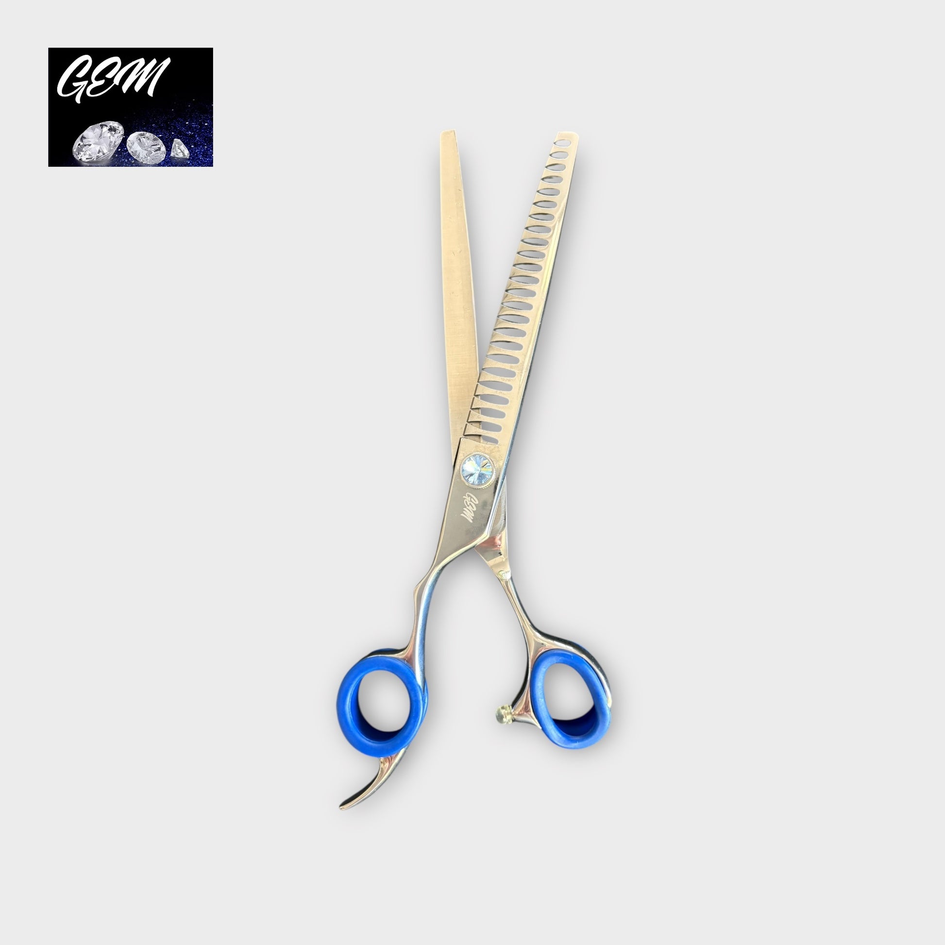 The GEM Blue Stone Straight Chunkers 7.5" Lefthanded Scissors feature blue finger grips and a forged design, shown on a light grey background with the GEM logo and gemstone images in the top left corner.