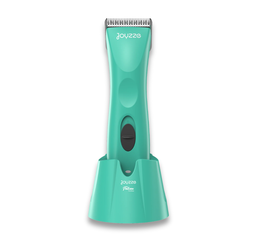 The Clipper Servicing stands upright in its teal charging base, featuring a front power button, silver top blades, and visible JOYSEE branding on both the clipper and base for convenient use and maintenance.