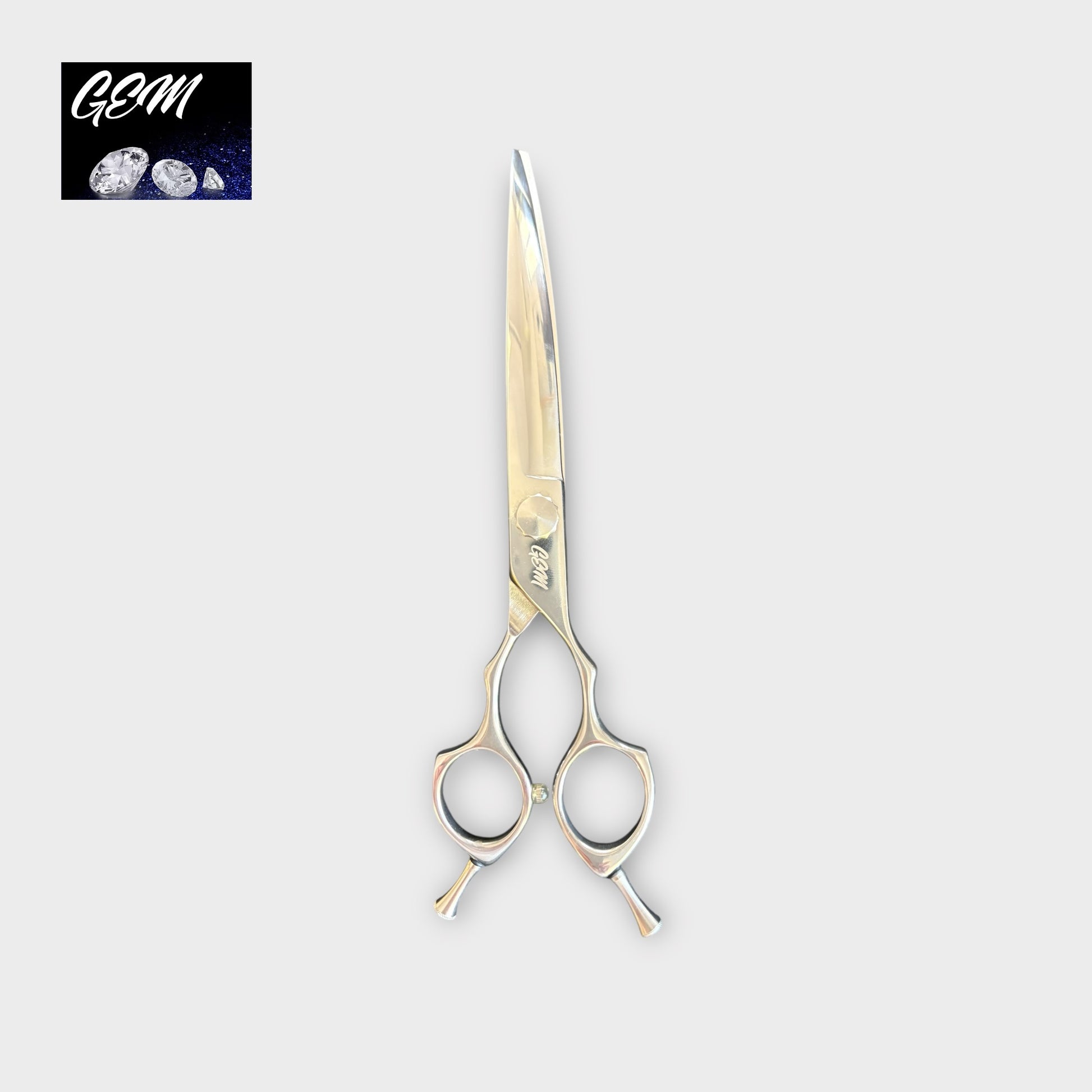 The GEM Supreme Curves 7.5" Scissors, featuring double finger rests and a shiny, professional design, are centered on a light gray background with the GEM logo and gemstone images in the top left corner.