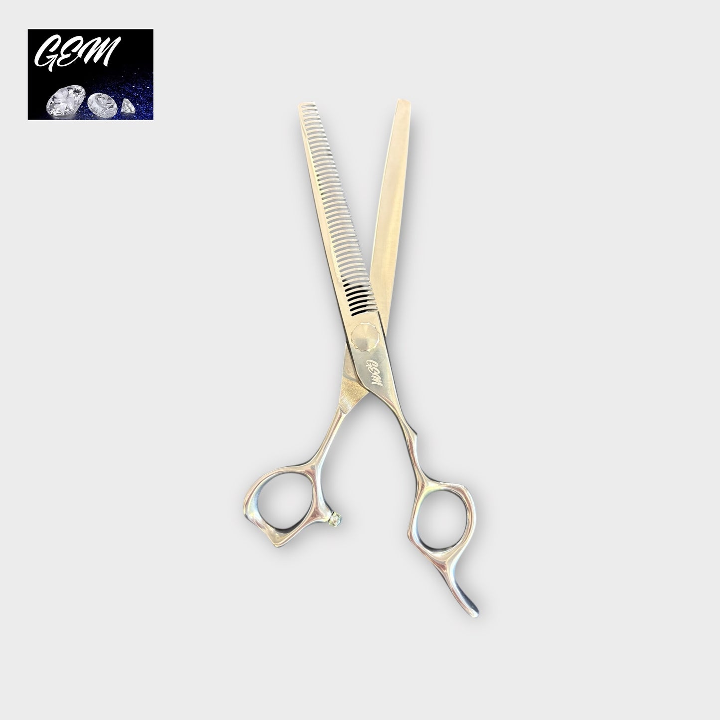 The GEM Supreme Straight Thinners 7" Scissors feature one serrated and one smooth blade. A GSM three-diamond logo appears in the top left on a white background. Perfect for precise thinning, comparable to Aichi Steel thinners.