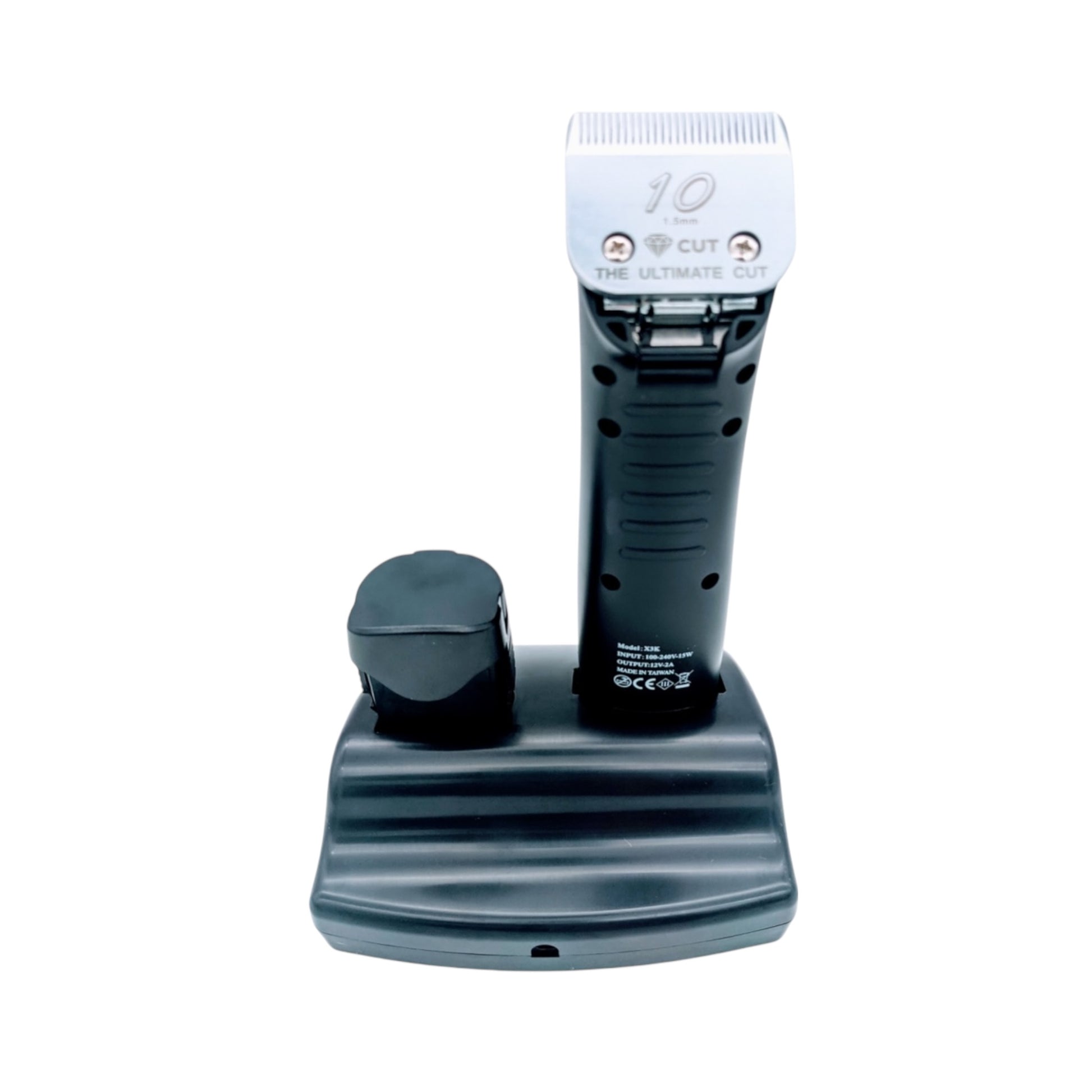 The X3K SE Cordless Pet Grooming Clipper - 2 Battery Pack stands upright on a charging base with a detachable size 10 blade labeled "The Ultimate Cut," offering quiet, high-performance trims for pets. Photographed on a white background.