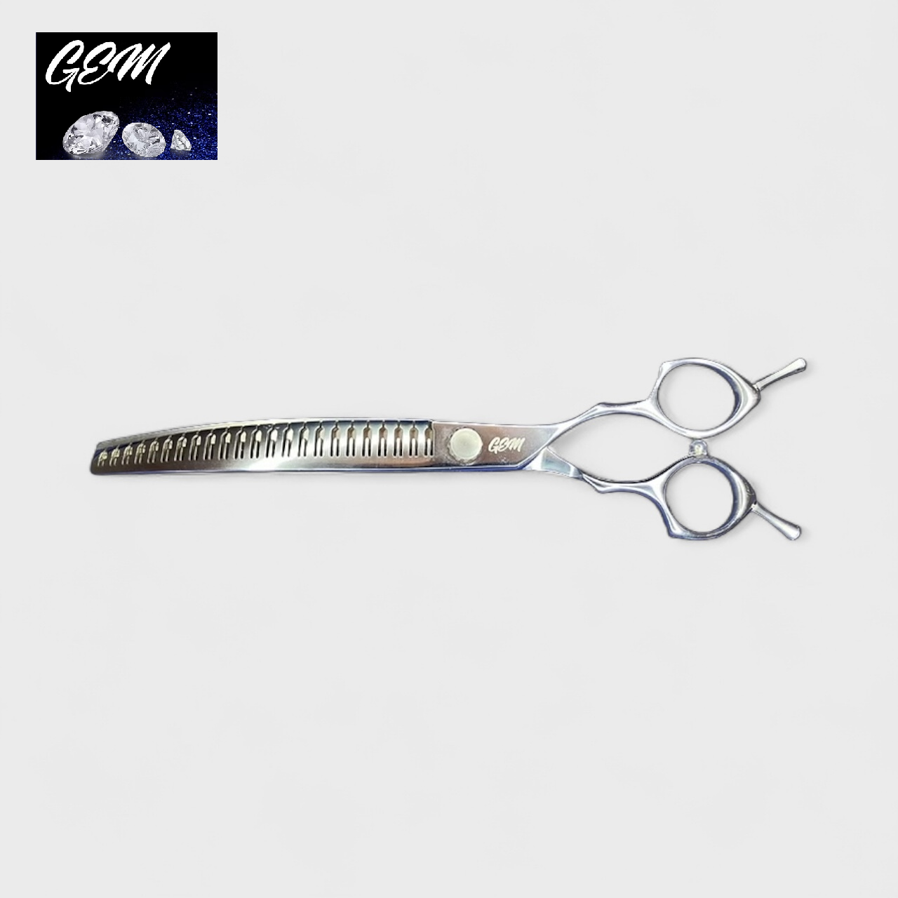 The GEM Supreme Curved Eraser 7.5" Scissors, made from Aichi steel with two finger holes and one serrated blade, are shown on a white background. The GEM logo with three diamonds appears in the top left corner.