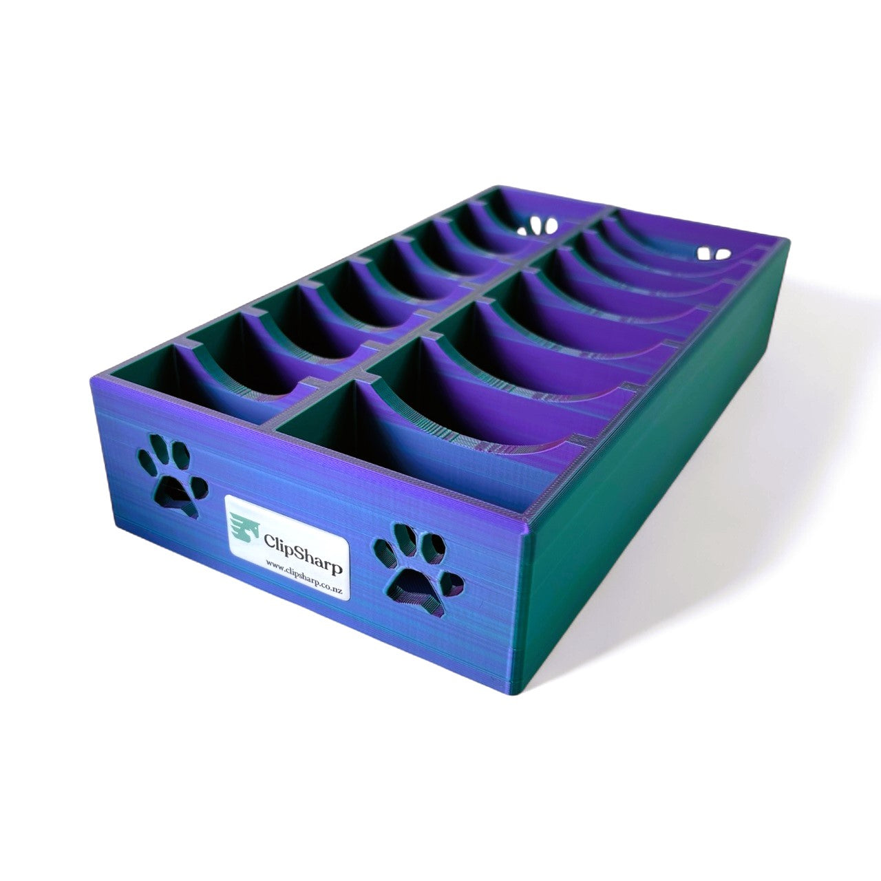 The Clip Sharp Multi Blade Tray is a blue and purple plastic organizer with curved slots for blades, paw print cutouts on the side, and a ClipSharp logo on the front—ideal for neat storage or organizing clipper blades.